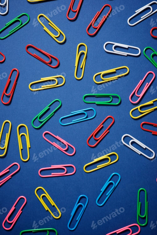 Preview: Paperclips Group On A Blue Table.