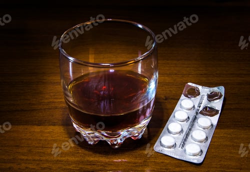 Preview: Glass Of The Whiskey With A Pills On The Table Closeup