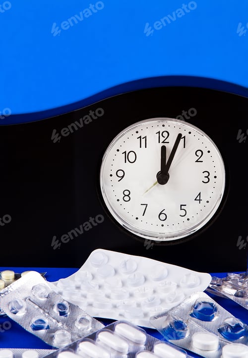 Preview: Clock With A Pills On The Blue Background Closeup