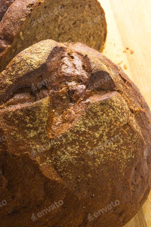 Preview: Sliced Dark Bread With Crumbs On Wood Board