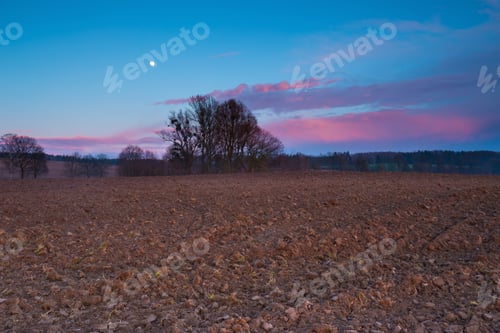 Preview: After Sunset Landscape Of Sky With Moon And Red Clouds Over Plowed Field.