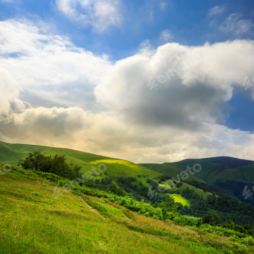 Preview: Mountain Summer Landscape. Forest Near Meadow On Hillside Under Sky With Clouds