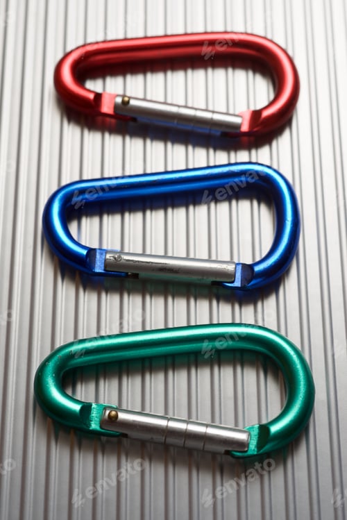 Preview: Small Carabiners On A Metal Table.