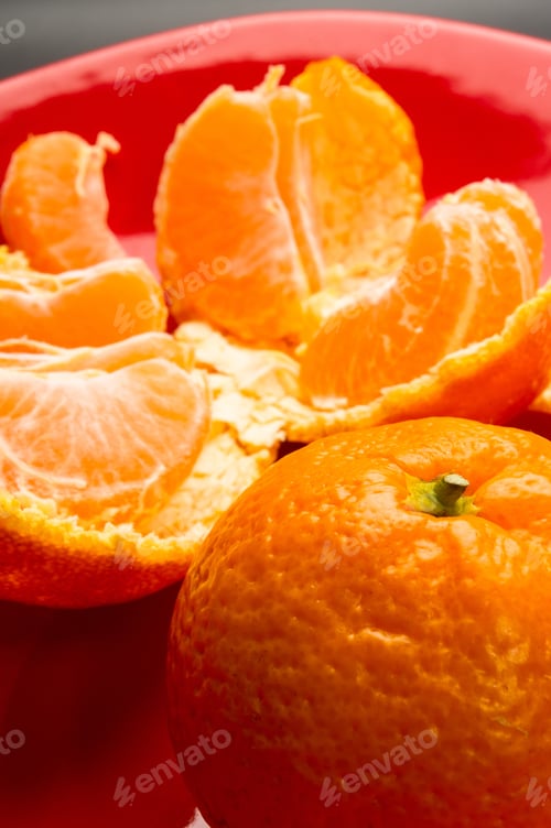 Preview: Tangerines, Peeled Tangerine And Tangerine Slices In A Red Plate On Black Background