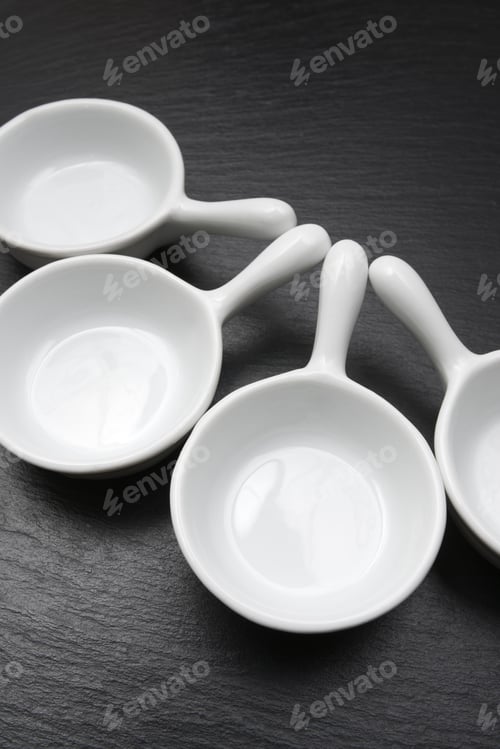 Preview: Four Small White Spoons On A Table Slate