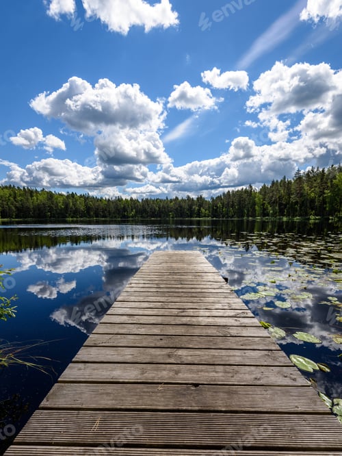 Preview: Reflection Of Clouds In The Lake With Boardwalk And Trees In Background
