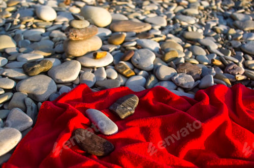 Preview: Red Towel And Stones On Pebble Beach, Sunset