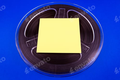 Preview: Vintage Reel With A Tape And Empty Paper On The Blue Cardboard Background