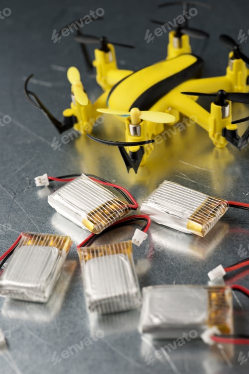 Preview: Yellow Drone And Batteries On A Metal Table.