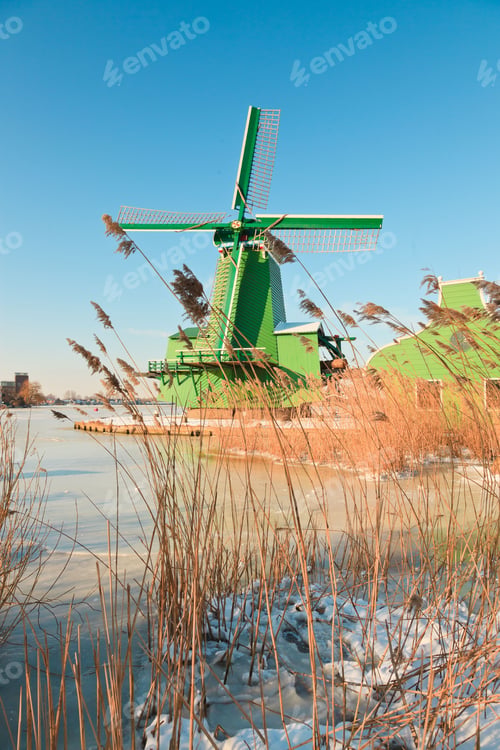 Preview: Winter Landscape Of Old Dutch Village With Windmill In Snow On Beautiful Clear Day. Blue Sky.