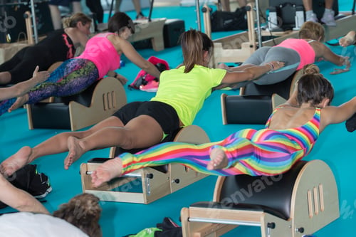 Preview: Girls In Sportswear Doing Fitness Back Exercises On Little Wooden Bench At Gym.