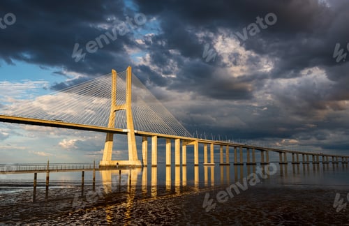 Preview: Vasco Da Gama Bridge At Sunset With Dramatic Cloudy Blue Sky In Lisbon, Portugal