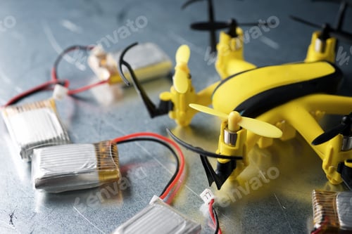 Preview: Yellow Drone And Batteries On A Metal Table.