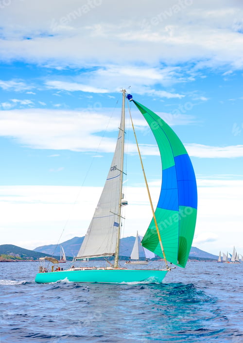 Preview: Sailing Boat With A Green - Blue Spinnaker During A Regatta Out Of Poros Island In Greece
