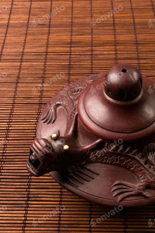 Preview: Brown Chinese Teapot Of Yixing Clay With Traditional Ornament On Bamboo Mat