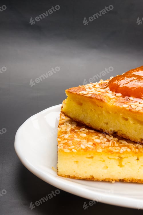 Preview: Slice Of Cheesecake With Sesame Seeds And Apricot Jam On A Black Background