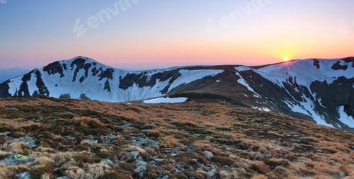 Preview: The Meadow With The Rocks And Yellow Grass. Landscape Of High Peaks Of Mountains Covered With Snow