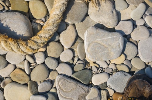 Preview: Old Worn Battered Marine Rope On The Pebble Beach On A Sunny Summer Day, Top View