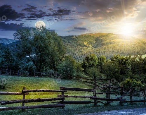 Preview: Day And Night Composite Image Of Wooden Fence On Agricultural Grassy Meadow With Trees On Hillside