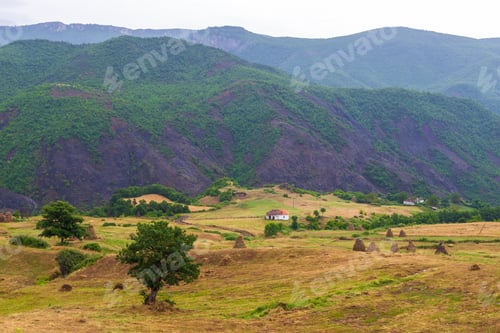 Preview: Scenic Landscape View In Albanian Mountain With Small Village And Hay Shocks.