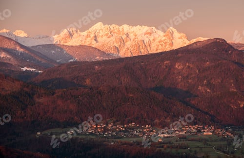 Preview: Village Under The Mountain At Sunrise. Mountains Are Already Covered With Snow.