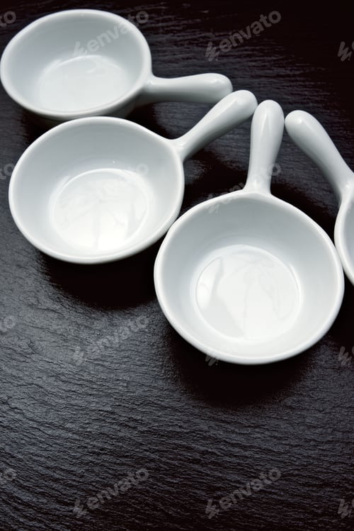 Preview: Four Small White Spoons On A Table Slate