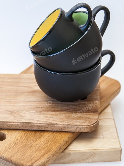 Black Cups Stacked on Wooden Cutting Boards