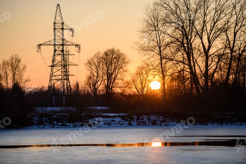 Preview: Colorful Winter Sunset With Trees And Power Lines In Background And Ice Blocks