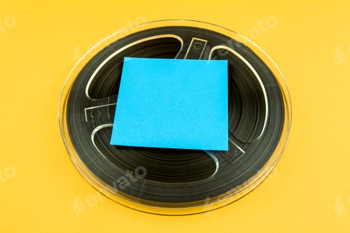 Preview: Vintage Reel With A Tape And Empty Paper On The Yellow Background