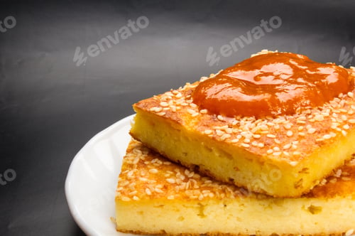 Preview: Slice Of Cheesecake With Sesame Seeds And Apricot Jam On A Black Background