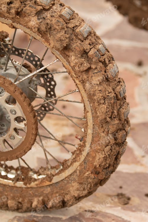 Preview: Motorcycle Wheel In Mud Clay Closeup On The Street.