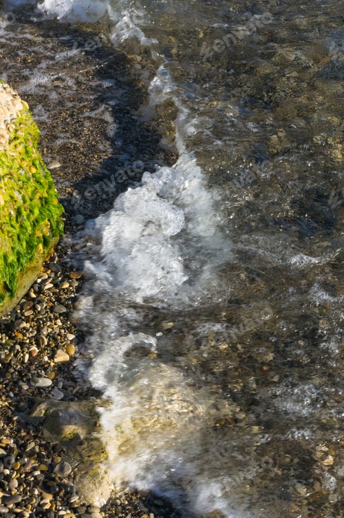 Preview: Rocky Sea Shore With With Seaweed, Transparent Waves With Foam, On A Warm Summer Day