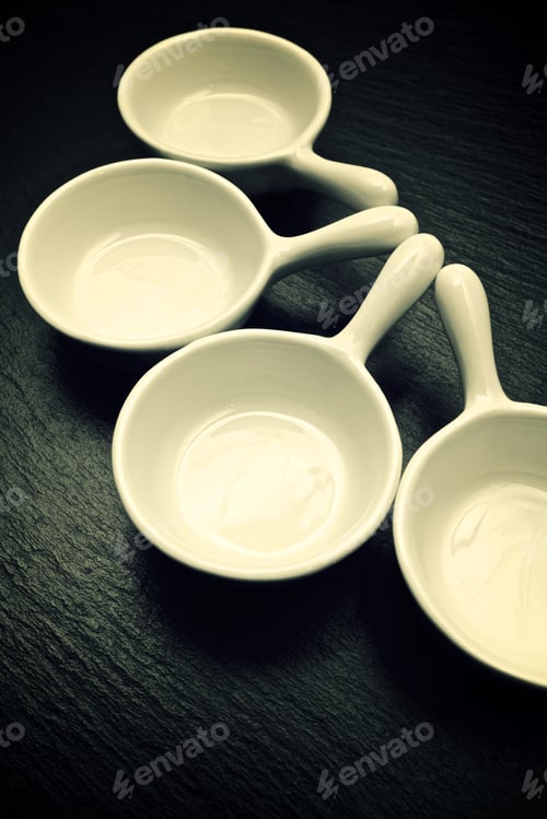 Preview: Four Small White Spoons On A Table Slate