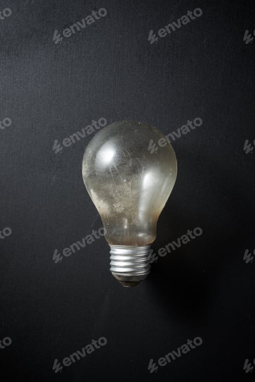 Preview: An Old Incandescent Bulb On A Black Table.