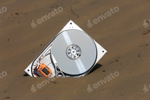 Preview: Abstract Broken Computer Hard Drive In Brown Sand
