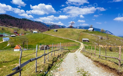 Preview: Landscape With A Rural Dirt Road In The Mountains Under Sky With Fluffy Clouds