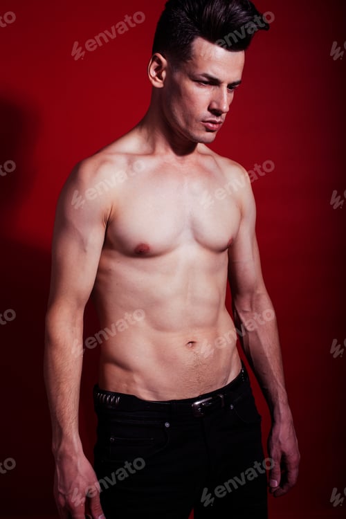 Preview: Young Fashion Style Man With Naked Torso Dancing Emotional Posing On Red Background, Lifestyle