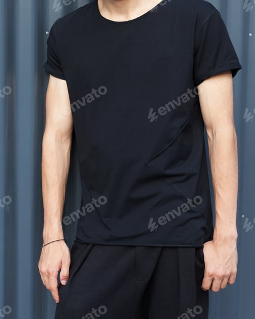 Preview: Fashion Of The Young. A Man In A Black T-Shirt Posing On A Metallic Dark Gray Background On A