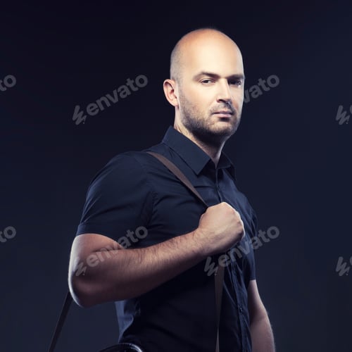 Preview: Handsome Man Wearing Black Summer Shirt, Bald Guy. Studio Portrait. Dark Background