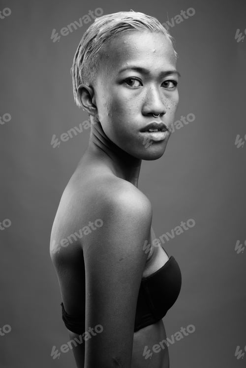 Preview: Young Beautiful Rebellious Woman With Short Hair Against Gray Background