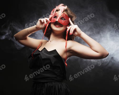 Preview: Beautiful Young Woman With Carnival Mask On A Black Background