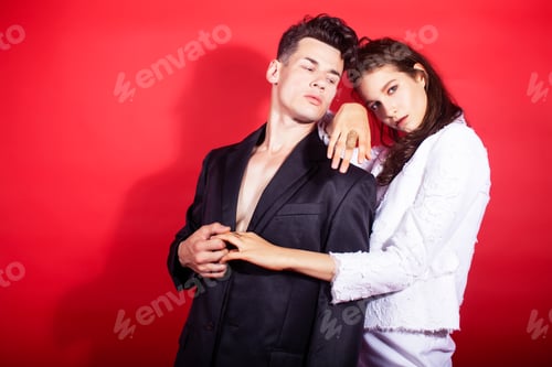 Vorschau: Junges Paar im Modestil, Mann und Frau auf rotem Hintergrund, Luxusartikel, Lifestyle, moderne Menschen