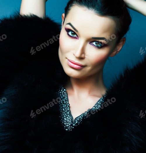 Preview: Young Pretty Brunette Girl With Fashion Makeup Posing Elegant In Fur Coat With Jewelry On Blue