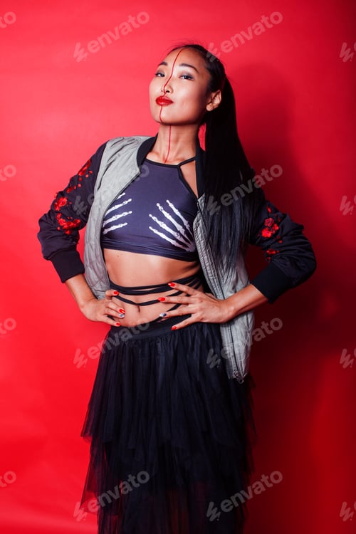 Preview: Young Pretty Asian Girl Posing Cheerful On Red Background, Fashion Makeup And Clothers