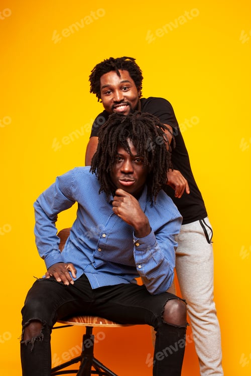 Preview: Two African American Guys Posing Cheerful Together On Yellow Background, Lifestyle People Concept