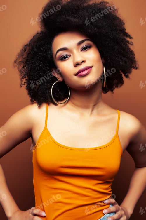 Preview: Pretty Young African American Woman With Curly Hair Posing Cheerful Gesturing On Brown Background
