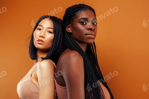 Preview: Young Pretty Asian, Afro Woman Posing Cheerful Together On Brown Background, Lifestyle Diverse