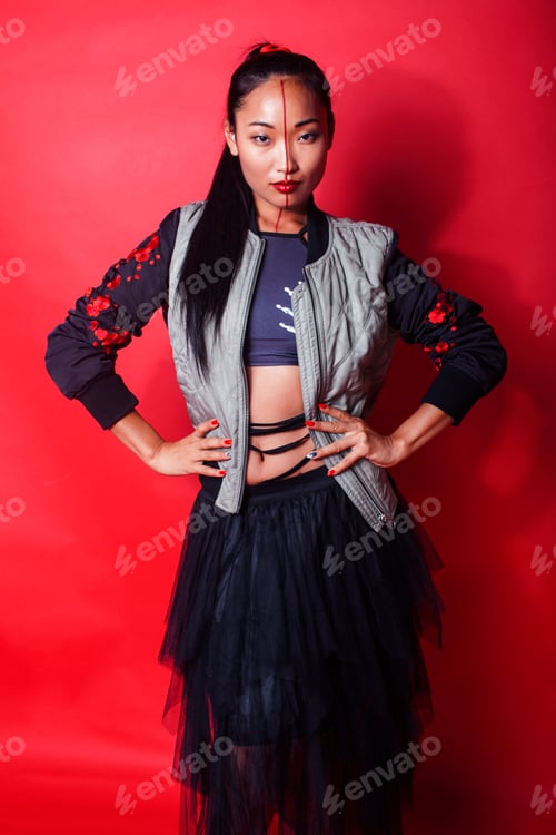 Preview: Young Pretty Asian Girl Posing Cheerful On Red Background, Fashion Makeup And Clothers