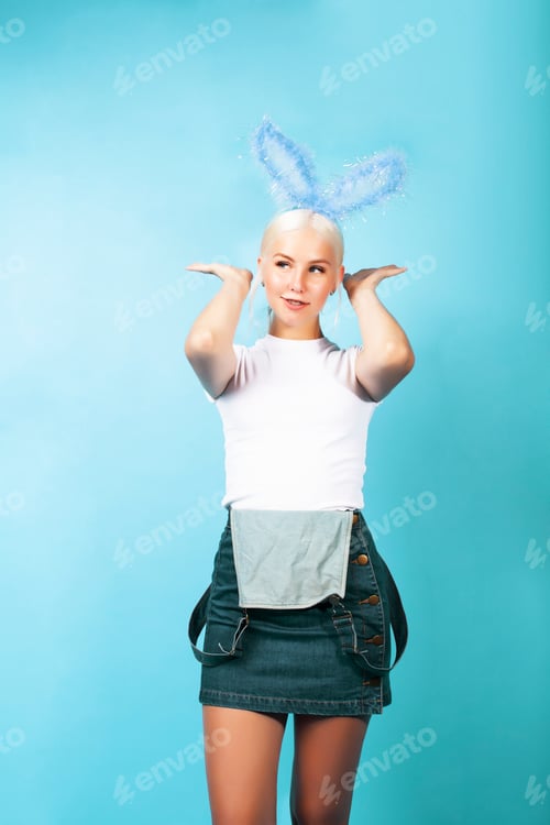 Preview: Young Pretty Blond Girl With Rabbit Ears Posing Cheerful On Blue Background, Lifestyle People