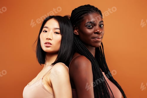 Preview: Young Pretty Asian And Afro Woman Posing Cheerful Together On Brown Background, Lifestyle Diverse